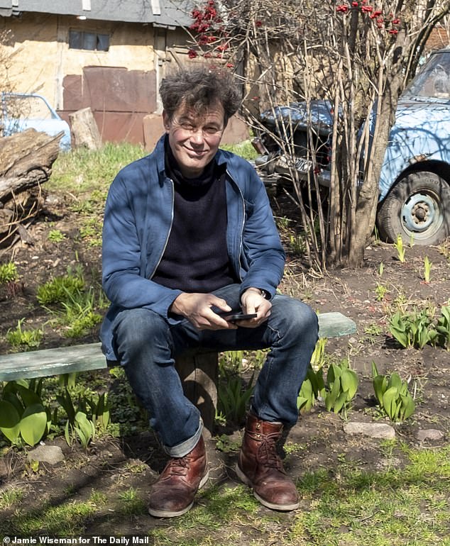 Richard uses his phone to take notes at Anatolii and Nadiâ's dacha outside Kyiv, where they returned for the first time with the Mail since the start of the war to check for damage and start planting this year's crops